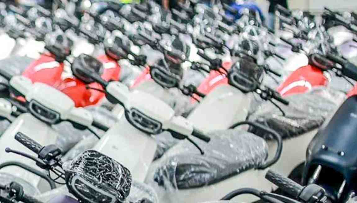 ओला इलेक्ट्रिक स्कूटर शोरूम के बाहर खड़ी गाड़ियां और गिरते स्टॉक ग्राफ का प्रतीकात्मक चित्र।